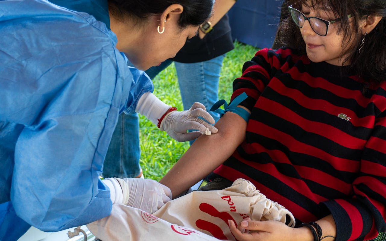 A donor giving blood at an outdoor donation event in Piura, Peru.